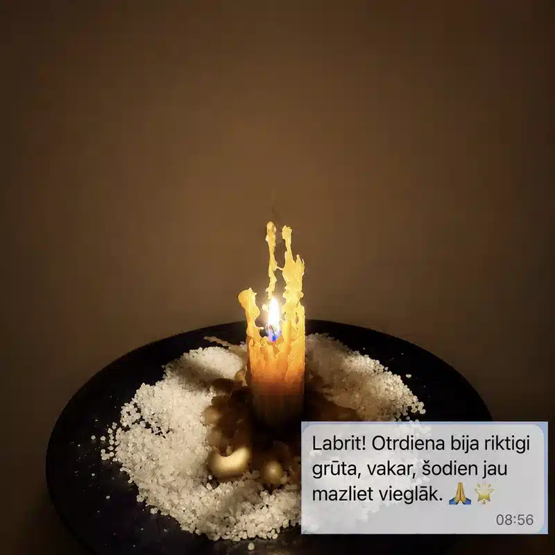 Degoša dzeltena vaska svece uz melna šķīvja ar sāli